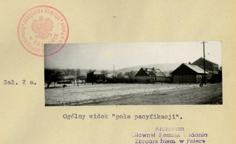 dokument z pieczęcią IPN i napisem "załącznik drugi. ogólny widok pola pacyfikacji" na żółtym papierze czarno-biała fotografia przedstawiająca panoramę wsi z okresu IIWŚ