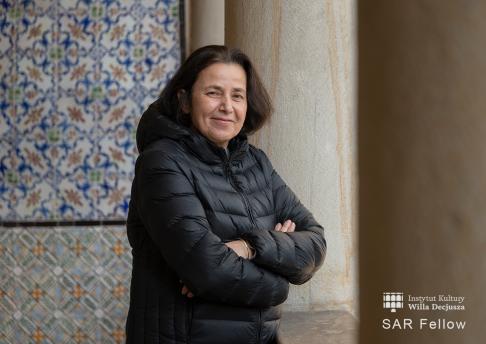 Fotografia portretowa kobiety w kurtce na tle orientalnych kafli