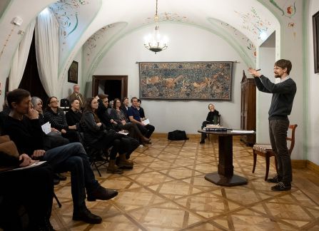 Fotografia mężczyzny z brodą przemawiającego do widowni