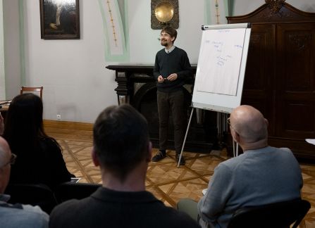 Fotografia mężczyzny z brodą przemawiającego do widowni