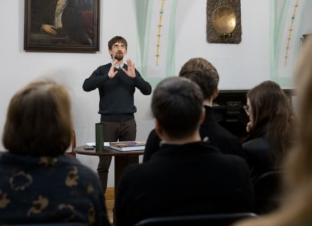 Fotografia mężczyzny z brodą przemawiającego do widowni