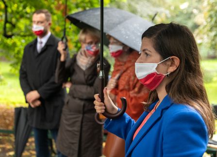 A photograph. People with umbrellas during the opening of an outdoor exhibition at planty in Krakow.