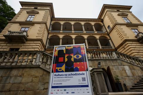 Fotografia fasady Willi Decjusza z plakatem Kultura na uchodzstwie