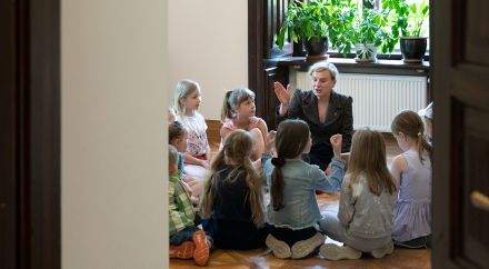 Zdjęcie grupy dzieci siedzących wokoło kobiety