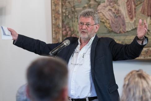 fotografia - zdjecie portretowe mężczyzny przemawiającego do zebranych gości