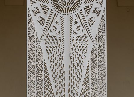 a photograph. large-format cutout with a traditional pattern, displayed between the columns of arcades on the facade of the Decius villa.